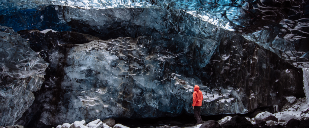 A person looking at a ice cave wall in Iceland.