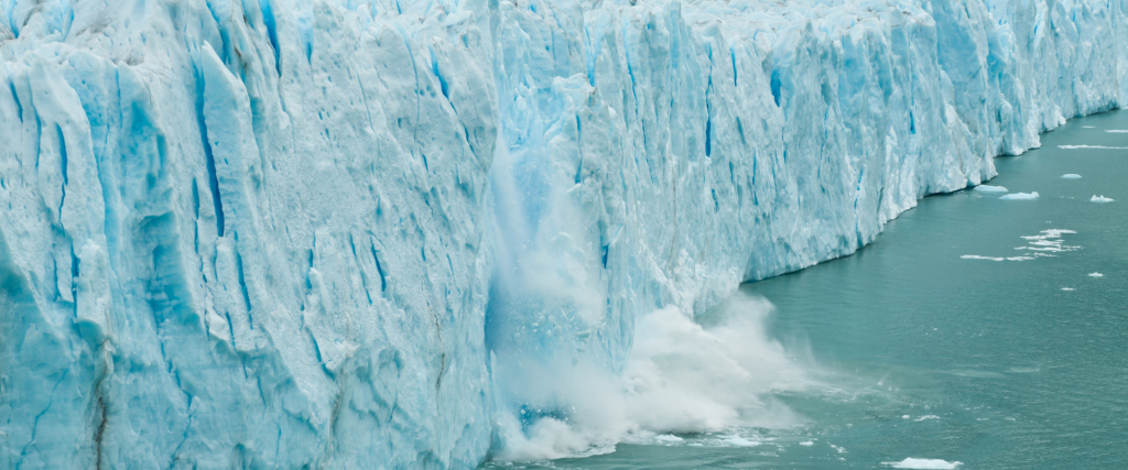 A piece of ice breaks off the glacier and into the water