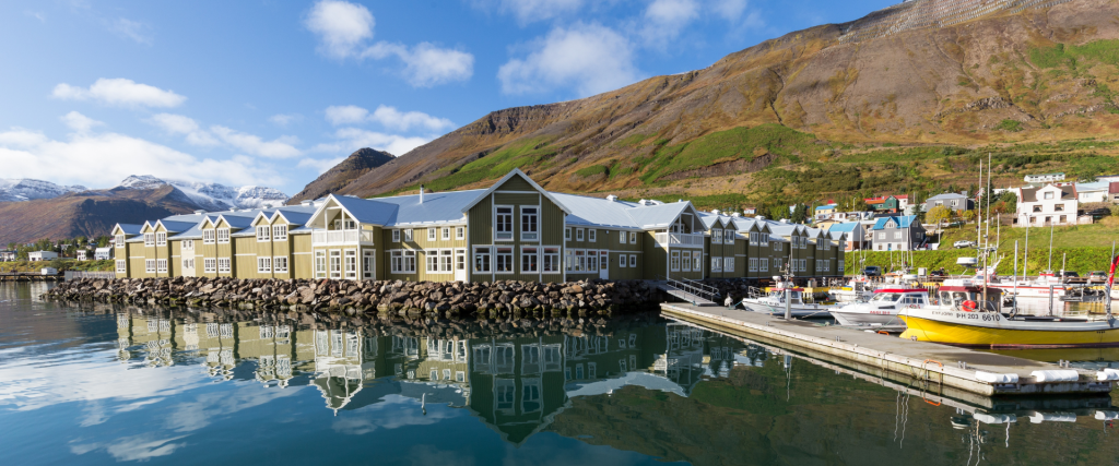 A photo showing Hotel Sigló in Siglufjörður and the harbour for small boats.